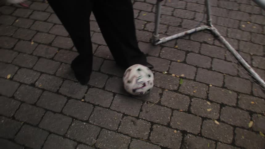 Closeup of a persons legs removing the soccer ball from the goal
