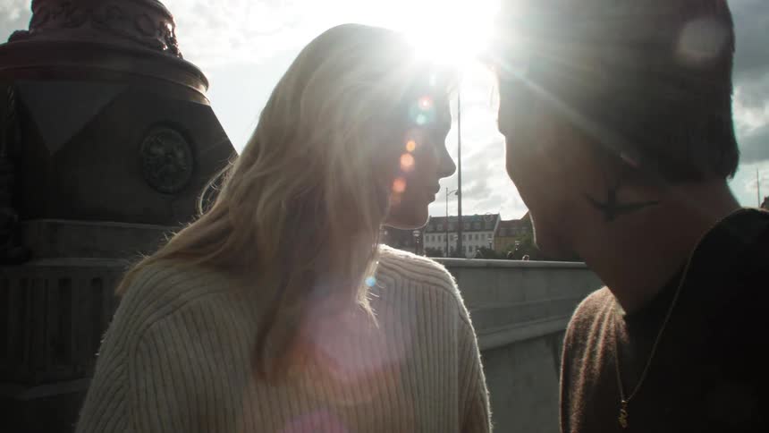 A sunny day with two people facing each other and chatting