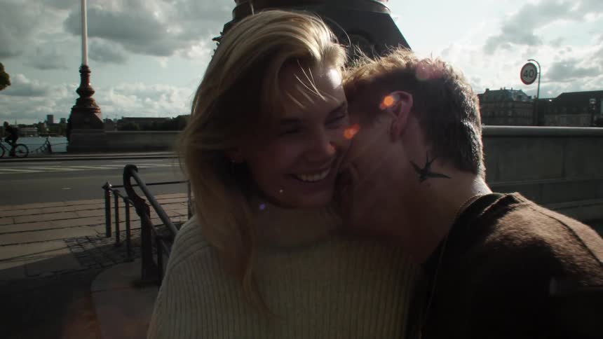 A couple laugh and touch in a city