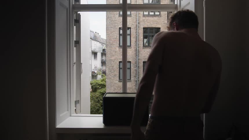 A man walking around in a room up to a box