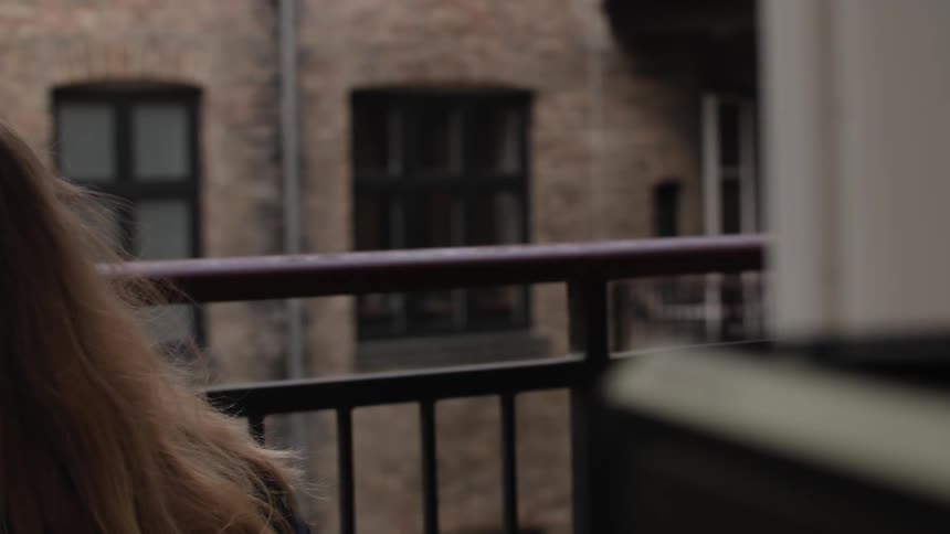 A couple kissing on the balcony of a building