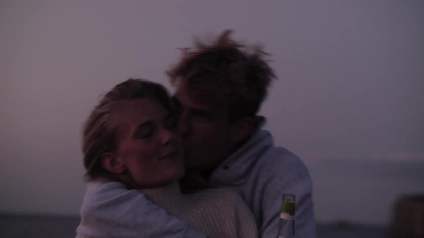 Couple hugging and happy kissing in an outdoor environment with their morning purple