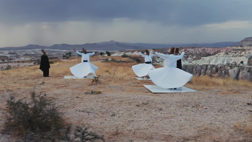 Sufi whirling dance performed in the desert on a cloudy day