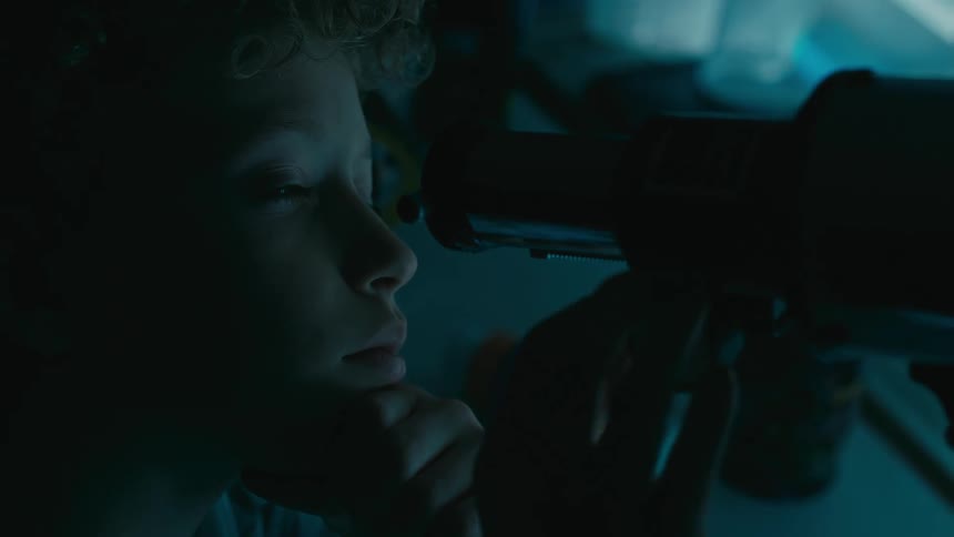 A boy using a telescope