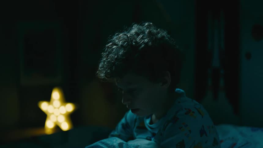 Portrait of a little boy who just woke up breathing deeply scared