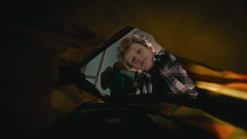A boy puts several items into a bag