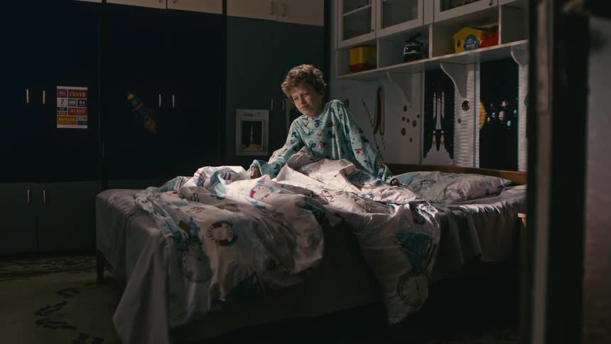 A sleepy boy wakes up on a comfortable bed in a cozy bedroom at home