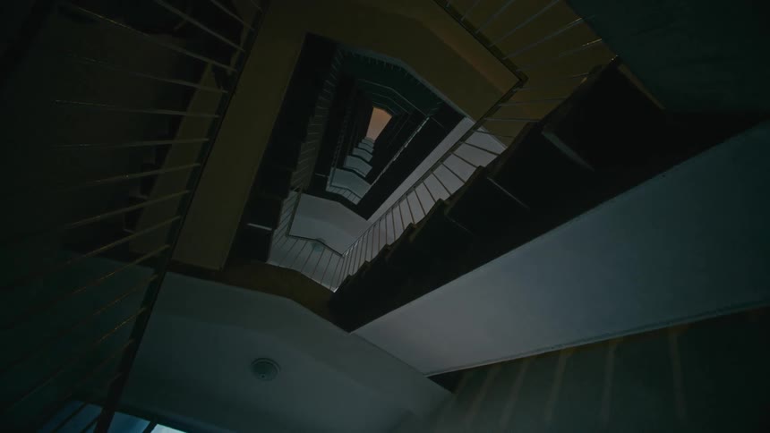Young boy walking down a hallway of stairs in a building