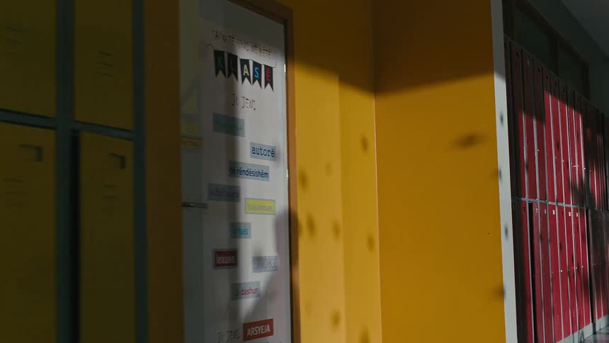 Shadow of two people passing by yellow and red school lockers