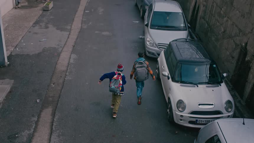 Boys run down a deserted neighborhood street on a cold day
