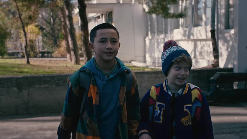 Two boys walking through a neighborhood alley during the day