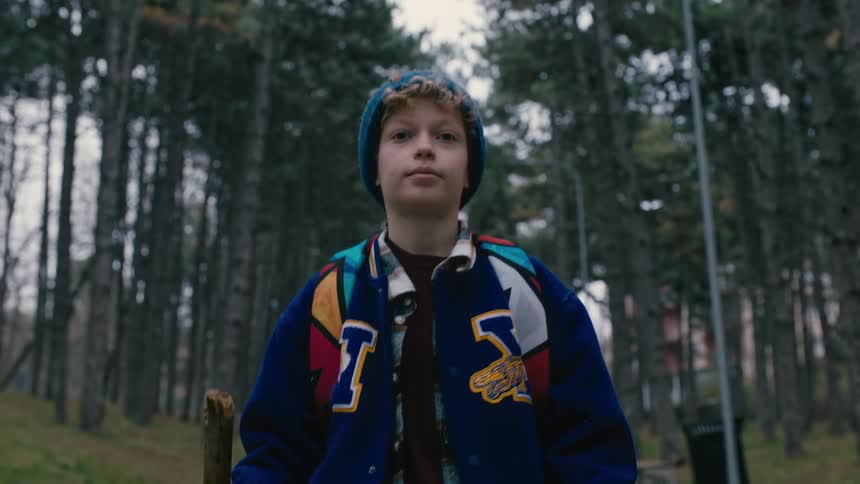 Little boy walking in a smiling forest