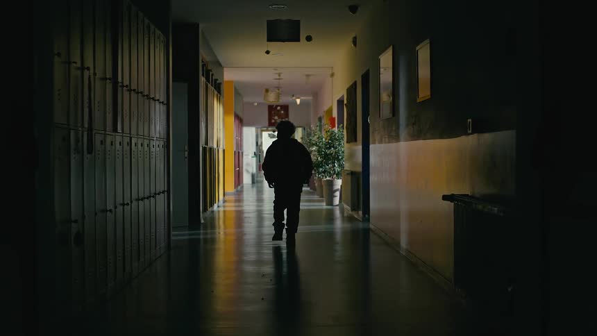 A child walks down the empty hall in the school