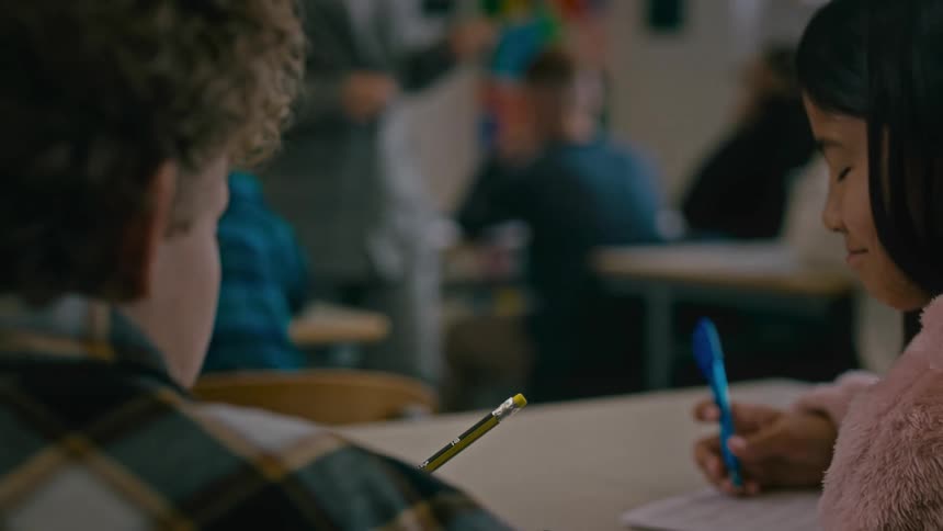 Teacher walks around classroom as students take test