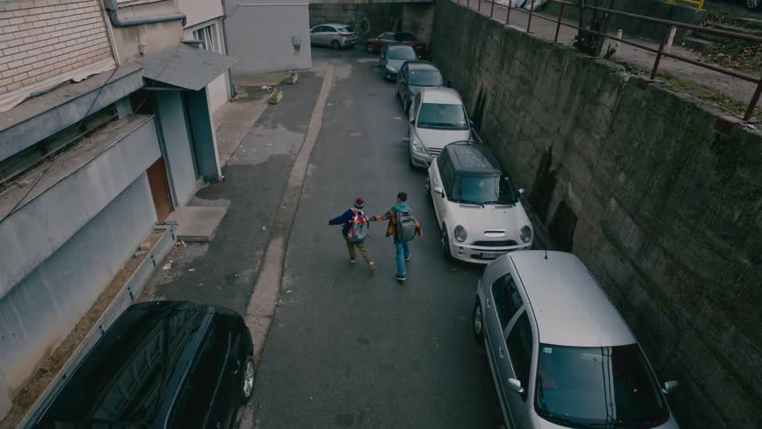 Two children walk down the alley