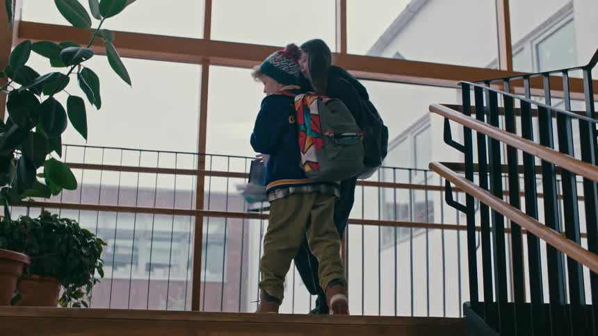 Little boy climbing the school stairs and bumping into a girl causing her books to fall and helping her pick up the books