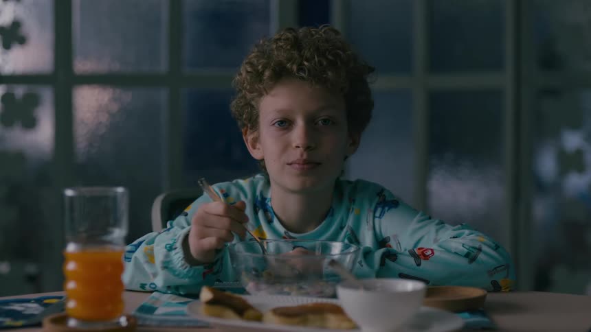 A young boy eats breakfast