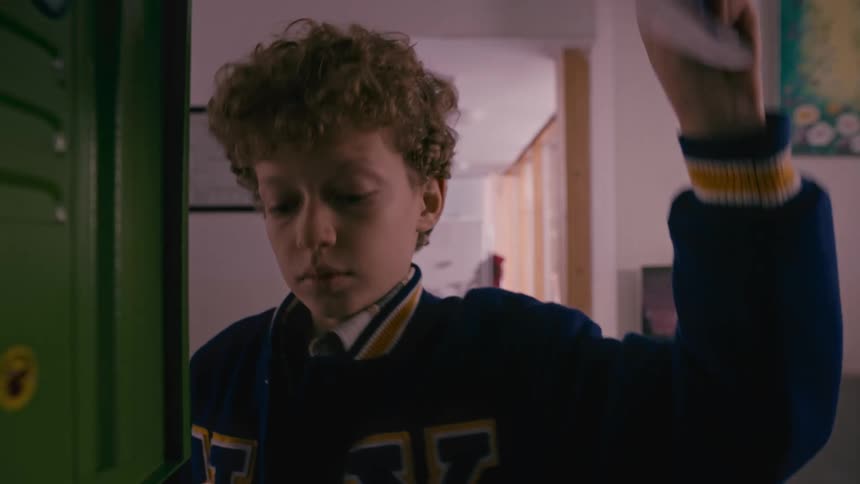 A boy takes books out of his school locker