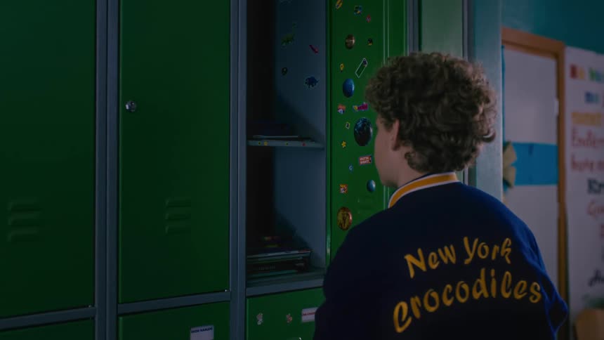 Little boy opening school locker and taking out books
