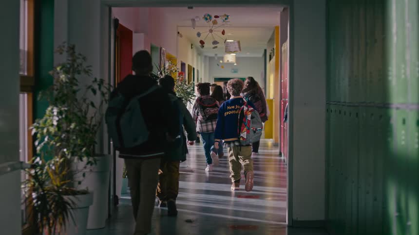A group of students walking in a hallway in a school
