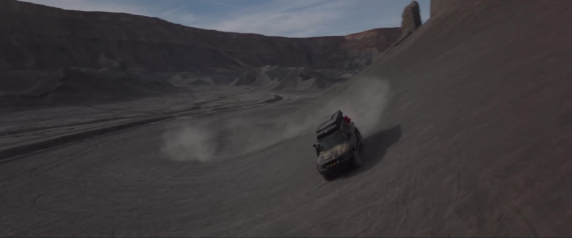 A car driving at high speed in the canyon desert during the day