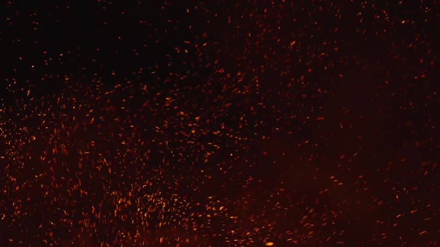 A raging fire burns and releases smoke and a large number of embers into the air