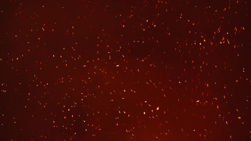 Many orange particles of sparks moving through the air