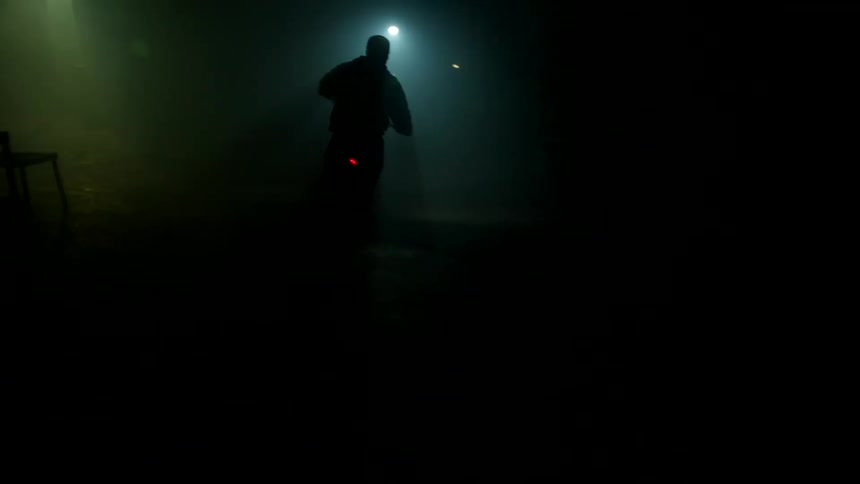 Someone driving a motorcycle in an almost completely dark room