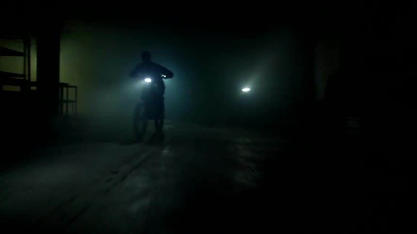 Motorbike spending the night on a darkened street with little lighting