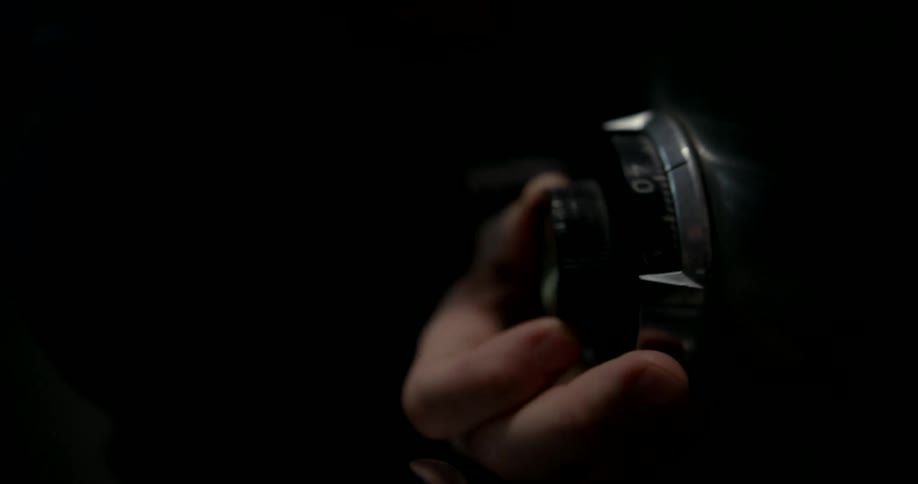 A hand turning a dial on a secure storage unit