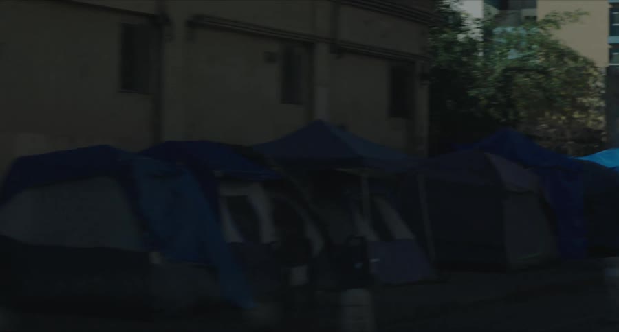 Many blue tents set up on a city street