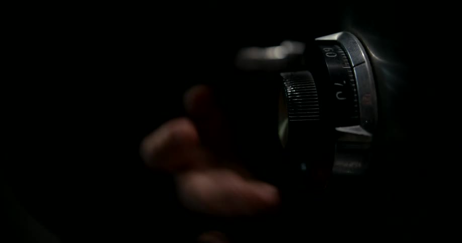Closeup of a mans hand opening a safe