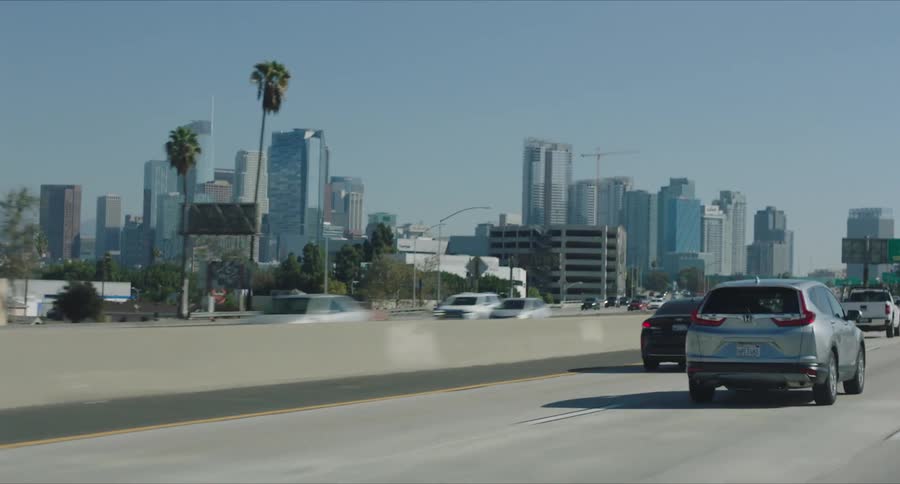 Skyline of a downtown Los Angeles on a sunny day from the POV of a car