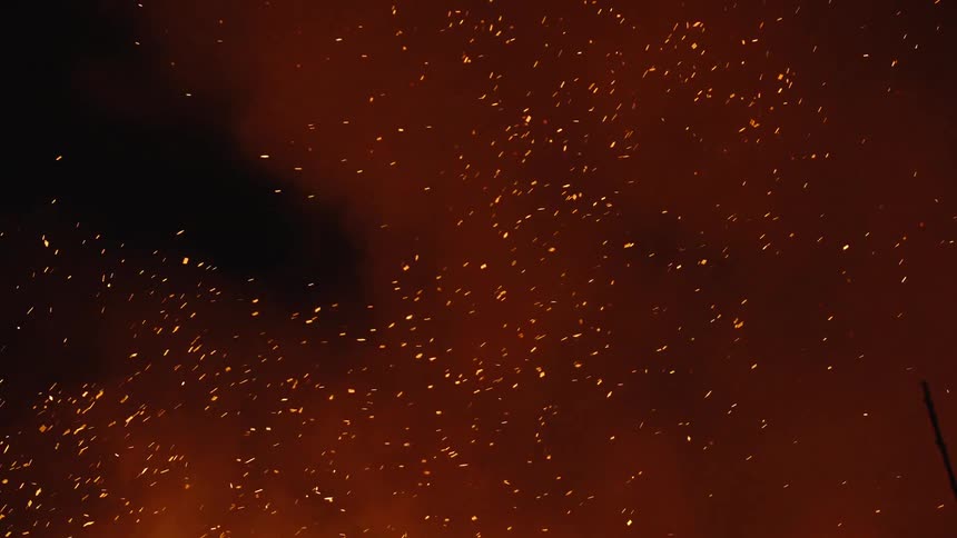 Smoke and fire shrapnel rising in the middle of the night