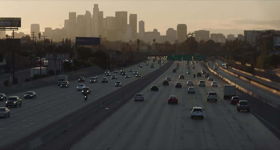 Panorama of a highway with vehicle traffic and skyscrapers of a metropolis in the background