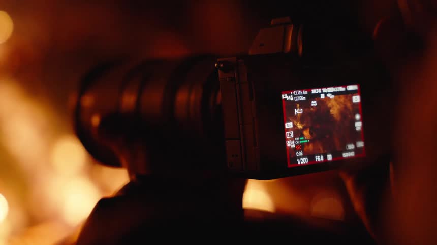 A person films a raging fire outdoors