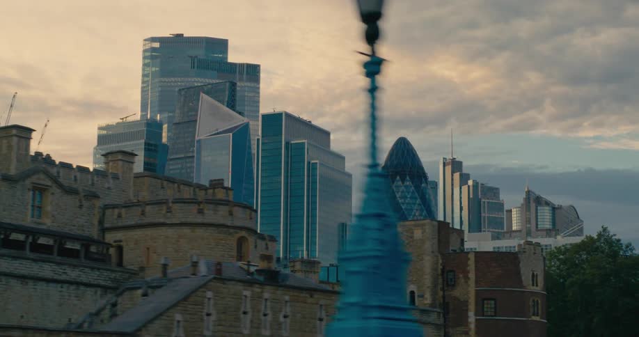 The gherkin and other buildings in london are seen from a moving car at sunset
