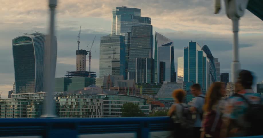 A city center with many tall buildings and in front there are several people standing admiring the place