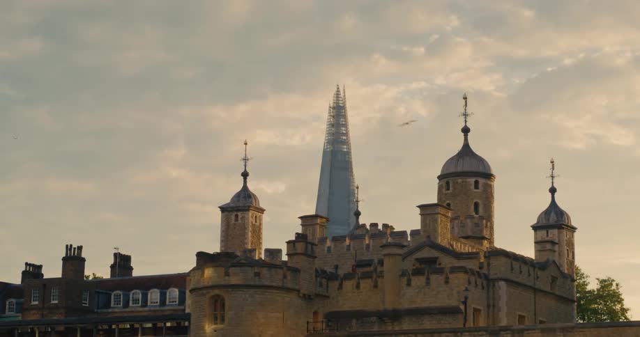 The shard skyscraper towers over landmark buildings under a cloudy sky