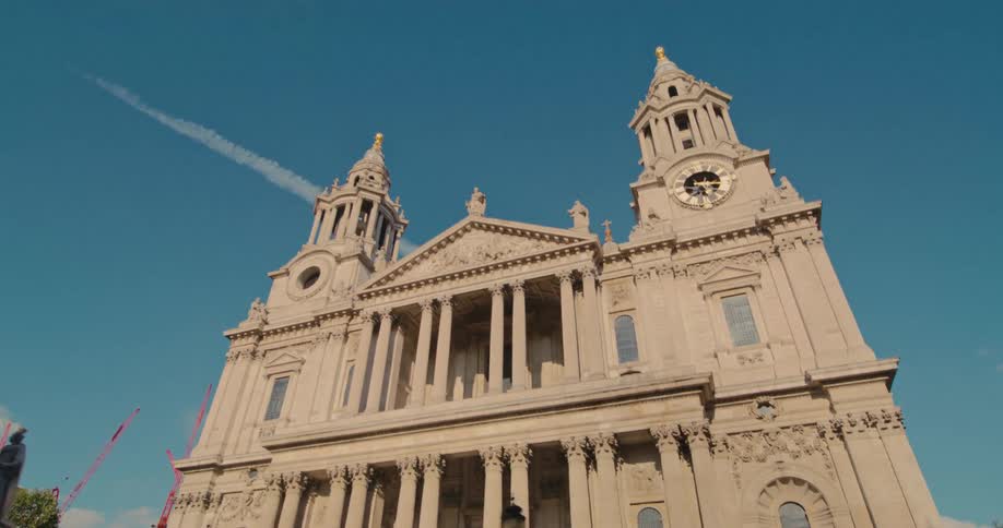 People walk around landmark building with a clock tower