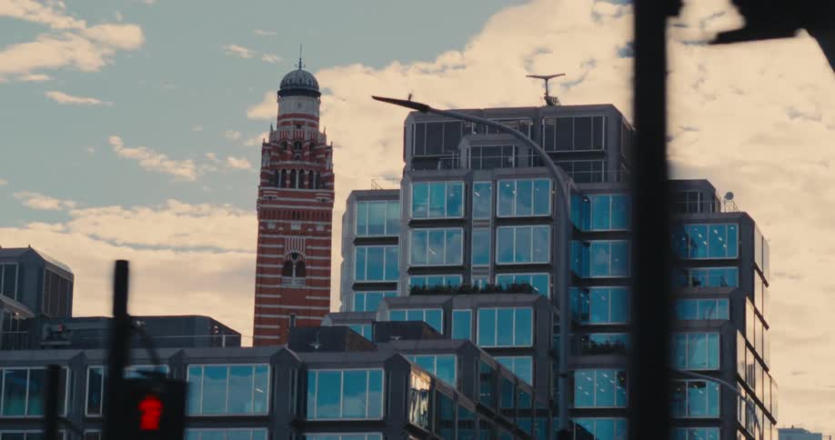 A commercial building with many glass windows and behind it there is a towershaped building