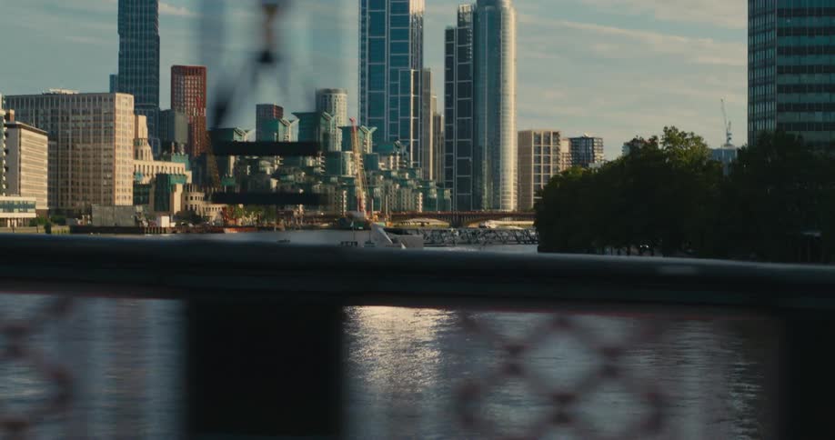 Bridge crosses river across from waterfront bordering downtown skyscrapers