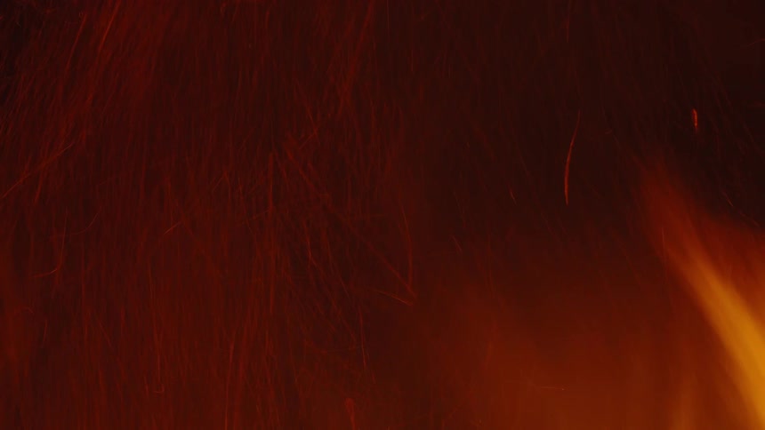 Sparks rise from roaring fire at night