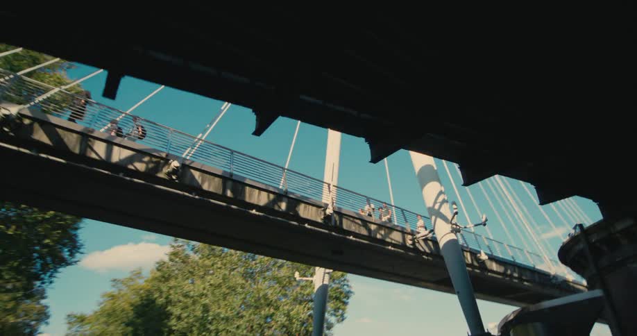 A bridge seen from below with several people walking over it