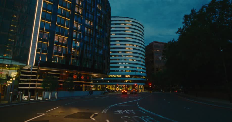 A city street at dusk in the city seen from a moving vehicle