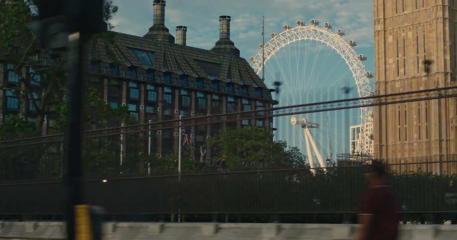 A ferris wheel behind some buildings in a city