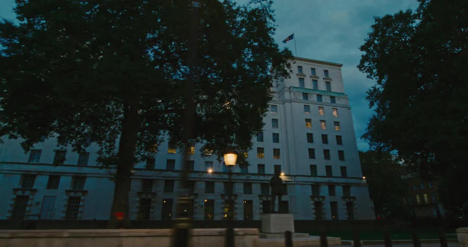 A statue is in front of the large building