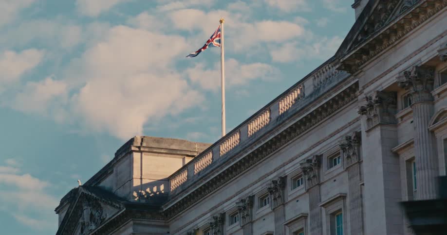 A parliament building with a flag waving against the wind