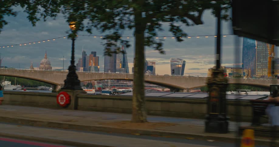 Bank of the River Thames with a view of the city skyline behind Waterloo Bridge