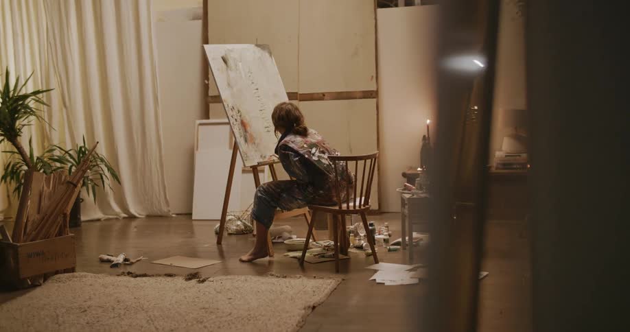 A woman painting a canvas in a large room